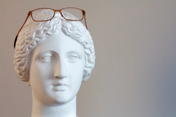 glasses on a plaster mannequin head on a grey background1