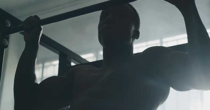Cinematic slow motion shot of a professional young muscular shirtless african man is practicing shadow boxing work out in a ring. 