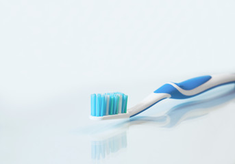Close up view of transparent toothbrush with blue bristles on white background. Healthy teeth, dental care concept. Space for text.
