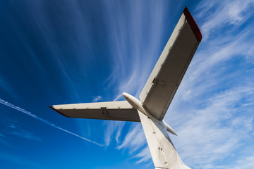 Tail of aircraft. White tail of aircraft on blue sky background.