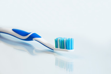 Close up view of transparent toothbrush with blue bristles on white background. Healthy teeth, dental care concept. Space for text.