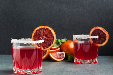 Glasses of blood orange margarite with salted rim, mint and slices of fruits