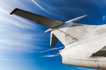 Fototapeta na wymiar Tail of aircraft. White tail of aircraft on blue sky background.