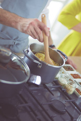 Couple cooking together in the kitchen at home