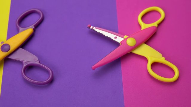 Set of a variety of wavy blade scissors for scrapbooking on colorful paper moves from right to left. Abstract minimal background with space for text.