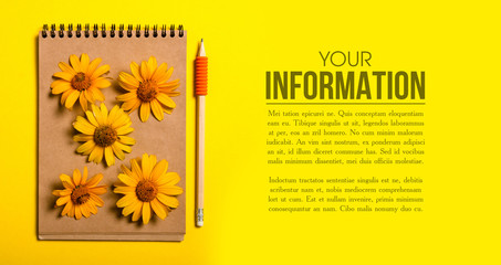 The notebook, flowers on orange yellow background, copy space
