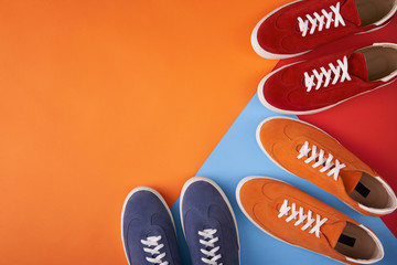 Colorful casual unisex suede trainers standing on multicolored background