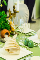 Christmas party dinner table setting with tableware and silverware and glasses set and Candlestick and flower in restaurant.