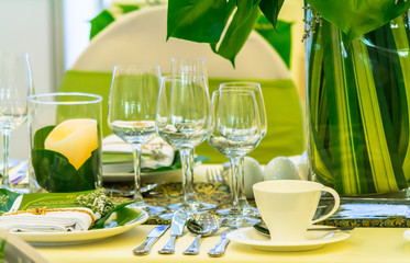 Christmas party dinner table setting with tableware and silverware and glasses set and Candlestick and flower in restaurant.