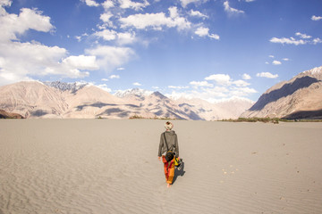 A woman traveler walking through a high alltitude desert in Nubra Valley, Ladakh, India. Great...