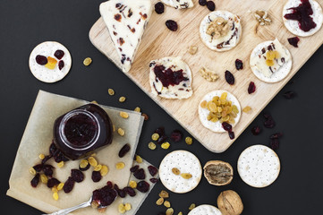 Platter with crackers and cranberry cheese with walnut, raisin, jam and dried cranberry