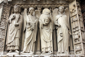 Paris, Notre-Dame cathedral, portal of the Virgin. From left to right: Emperor Constantine, an angel, Saint Denis holding his head, and another angel.