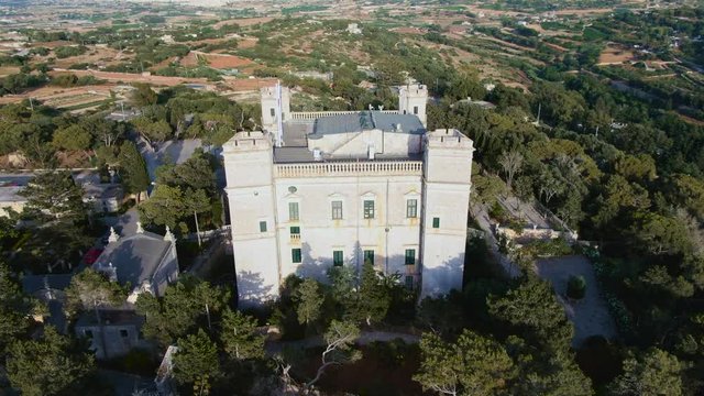 Close up clockwise aerial view of the Verdala Place and the Chapple near the Buskette Fields in Malta,