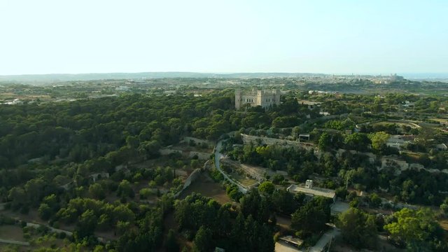 Aerial view flying towards Verdala Castle over the Buskette Terraced fields in Malta