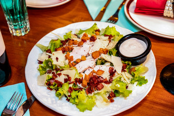 Fresh salad with smoked chicken. Fresh vegetables, herbs, olives, sauce and salad dressing at the counter.  Details close-up and soft focus. Vegetarian food and snacks. 