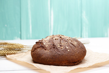 Homemade Black bread. Bread of rye dough on a craft paper. Rye bread for dinner. Fresh fragrant delicious homemade pastries.