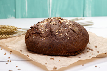 Homemade Black bread. Bread of rye dough on a craft paper. Rye bread for dinner. Fresh fragrant delicious homemade pastries.