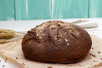 Homemade Black bread. Bread of rye dough on a craft paper. Rye bread for dinner. Fresh fragrant delicious homemade pastries.