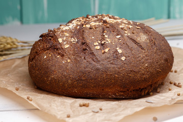 Homemade Black bread. Bread of rye dough on a craft paper. Rye bread for dinner. Fresh fragrant delicious homemade pastries.