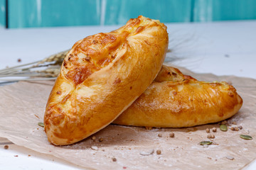 Homemade samsa with cheese. Delicious cheese pie on a craft paper. Pie for dinner. Fresh fragrant delicious homemade pastries.