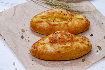 Homemade samsa with cheese. Delicious cheese pie on a craft paper. Pie for dinner. Fresh fragrant delicious homemade pastries.