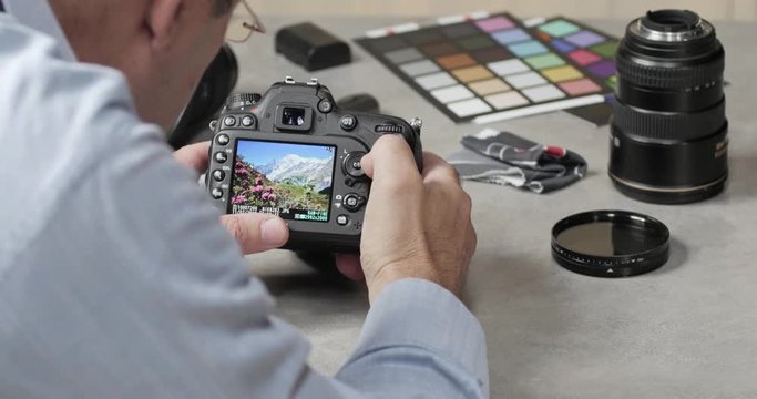 Un photographe v&eacute;rifie ses photographies sur l'ecran de controle de son boitier reflex num&eacute;rique 