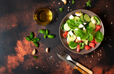 Fresh vegetable salad with mozzarella and basil served with olive oil and sea salt. Mediterranean, Spanish, Italian cuisine. Top view. Copy space