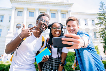 Happy interracial boys and african girl friend posing for cute selfie.Young friends in t-shirts...