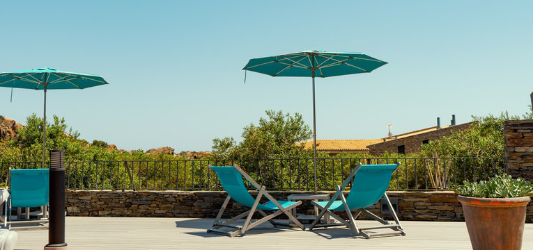 Umbrella And Sun Chair On Blue Summer Sky