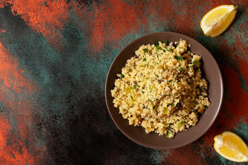 Traditional couscous with vegetables and herbs in a bowl. Levantine vegetarian salad. Lebanese, arabic cuisine. Top view. Copy space