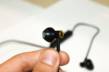 bluetooth headphones in hand on white background close on top