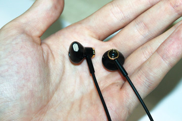 bluetooth headphones in hand on white background close on top