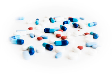 Pills and capsules on white background