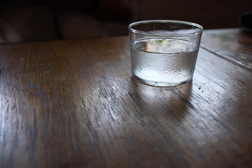 木製テーブルの上の結露した水のグラス