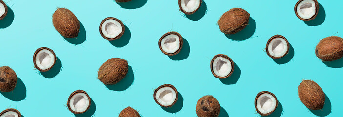 Creative layout of coconuts half on blue background. Tropical pattern, top view or flat lay. Hard...