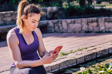 sporty woman sitting writing at the phone