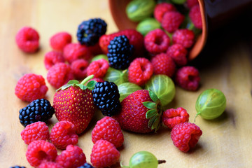 Different berries on a wooden background