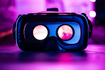 3d 360 vr headset glasses goggles lenses in futuristic purple neon light on table, virtual...