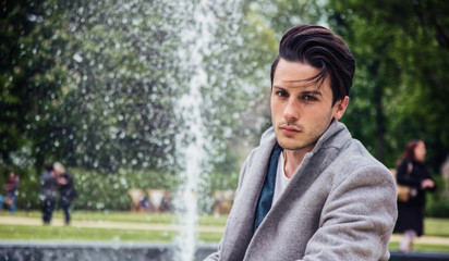 Elegant attractive young man outdoor wearing wool coat, in European city
