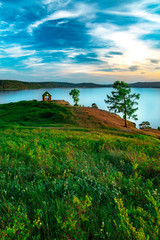 Beautiful landscape view of the mountain lake Turgoyak, Russia with cloudy sky and summer house on the hill in summer