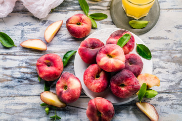 Reife und saftige Pfirsiche auf dem hellem tisch mit frischem Saft im Hintergrund