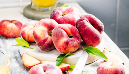 Reife und saftige Pfirsiche auf dem hellem tisch mit frischem Saft im Hintergrund