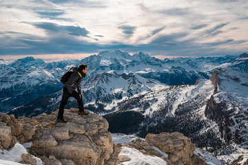 hiking explorer on top of mountain looking for direction in front of dolomites landscape in Cortina surroundings. 