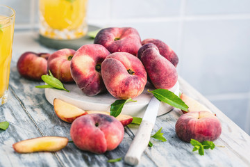 Reife und saftige Pfirsiche auf dem hellem tisch mit frischem Saft im Hintergrund