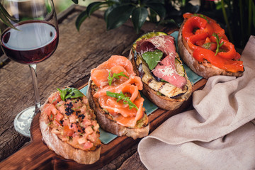 bruschetta on a wooden board with a glass of wine