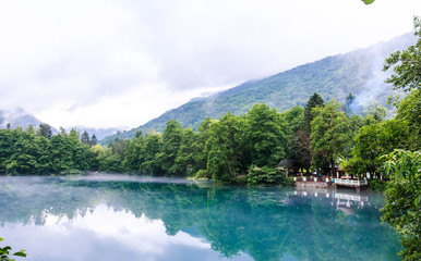 Gazebo for relaxing on the shore of the blue karst lake Cerik-Kel in cloudy foggy weather,...