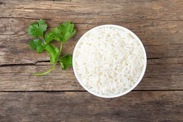 Boiled rice in a bowl on wooden rustic table.