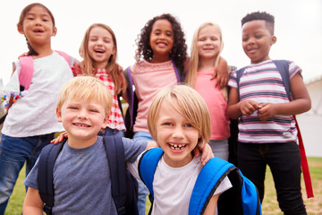 Portrait Of Excited Elementary School Pupils On Playing Field At Break Time