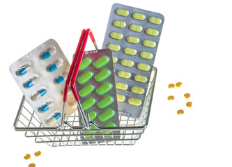 Tablets are different, colored lie in a mini basket as shopping, isolated on a white background.
