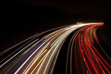 Leuchtspuren der Scheinwerfer von Autos bei Nacht auf der Autobahn bei Langzeitbelichtung